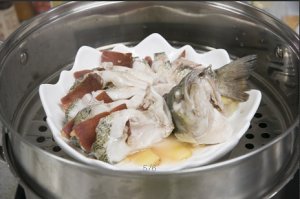 將鱸魚成花狀擺好，將火腿切片放入各縫隙中，放入鍋中隔水蒸12分鐘拿出，撒上蔥花即可。