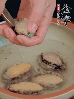 鮑魚加鹽、清水浸泡，用勺子挖出鮑魚肉。