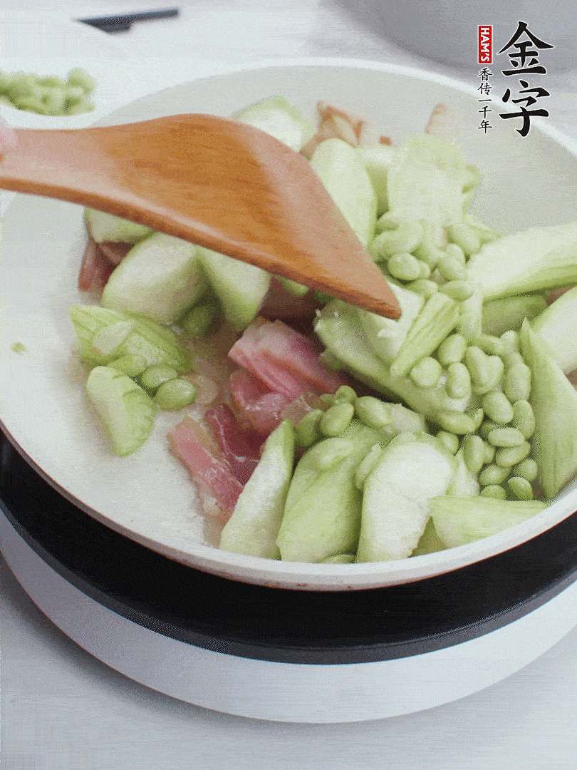 依次下絲瓜、青豆翻炒，炒至絲瓜打蔫縮小。