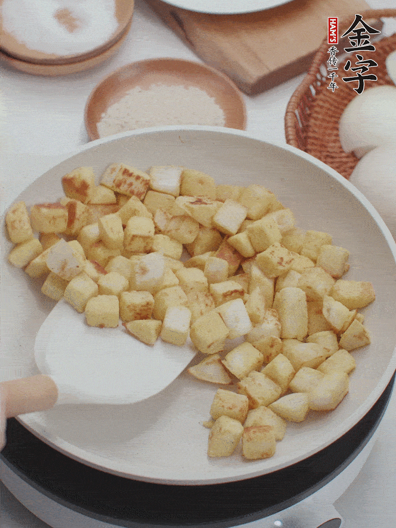 起鍋熱油，倒入饅頭丁，小火煎至蛋液凝固定型再翻面，饅頭丁部煎至金黃時盛起待用。