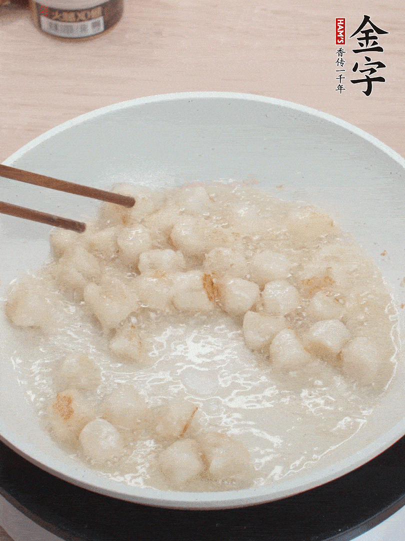 油溫4成熱，鮮貝蘸干淀粉下鍋煎，一面微黃后翻面。