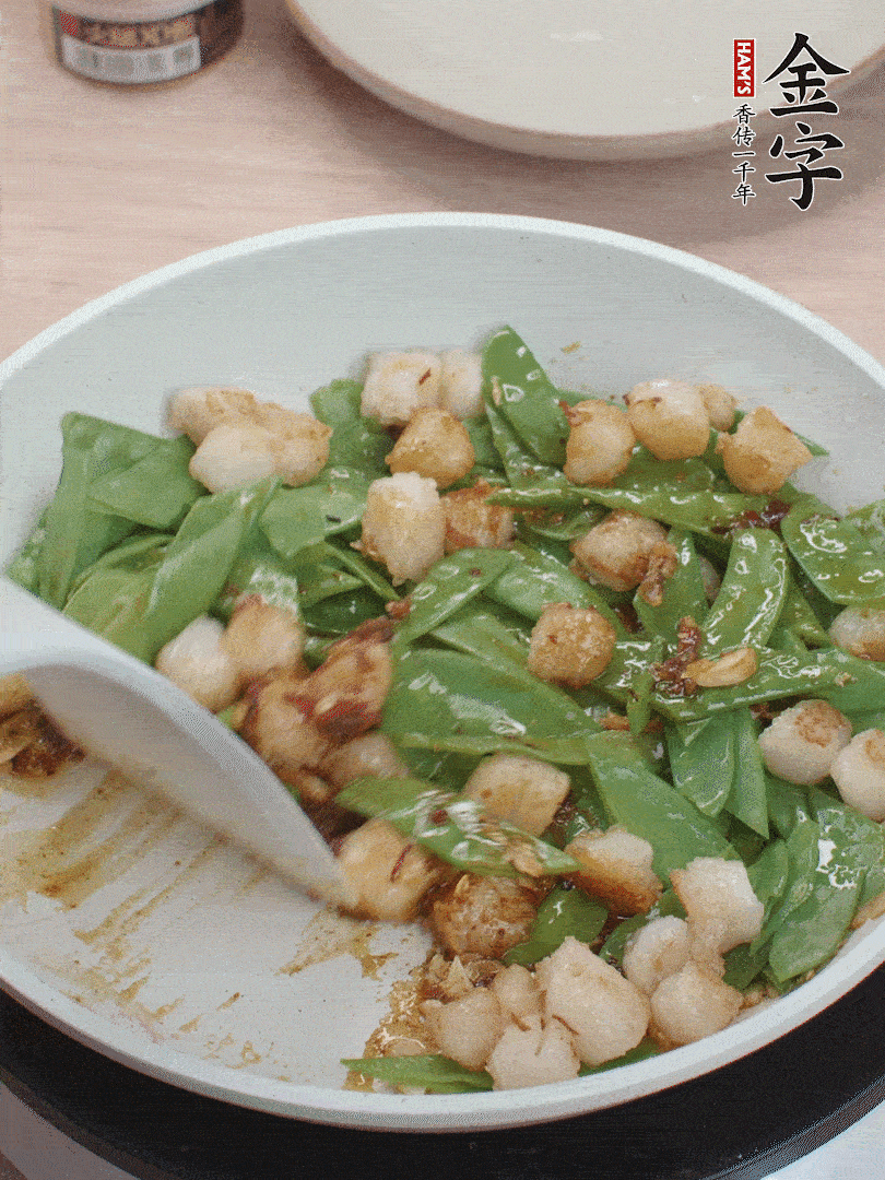 下甜豆莢、鮮貝輕輕翻炒均勻。