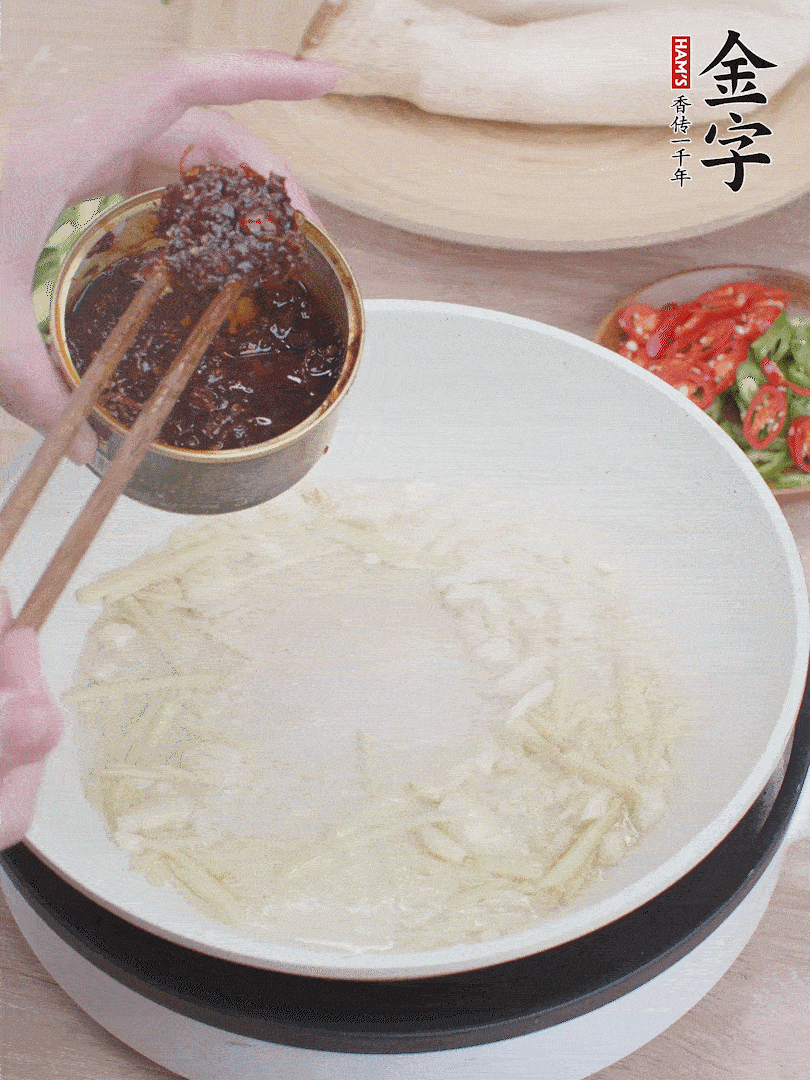 起鍋熱油，姜蒜、金字火腿干貝醬煸香。