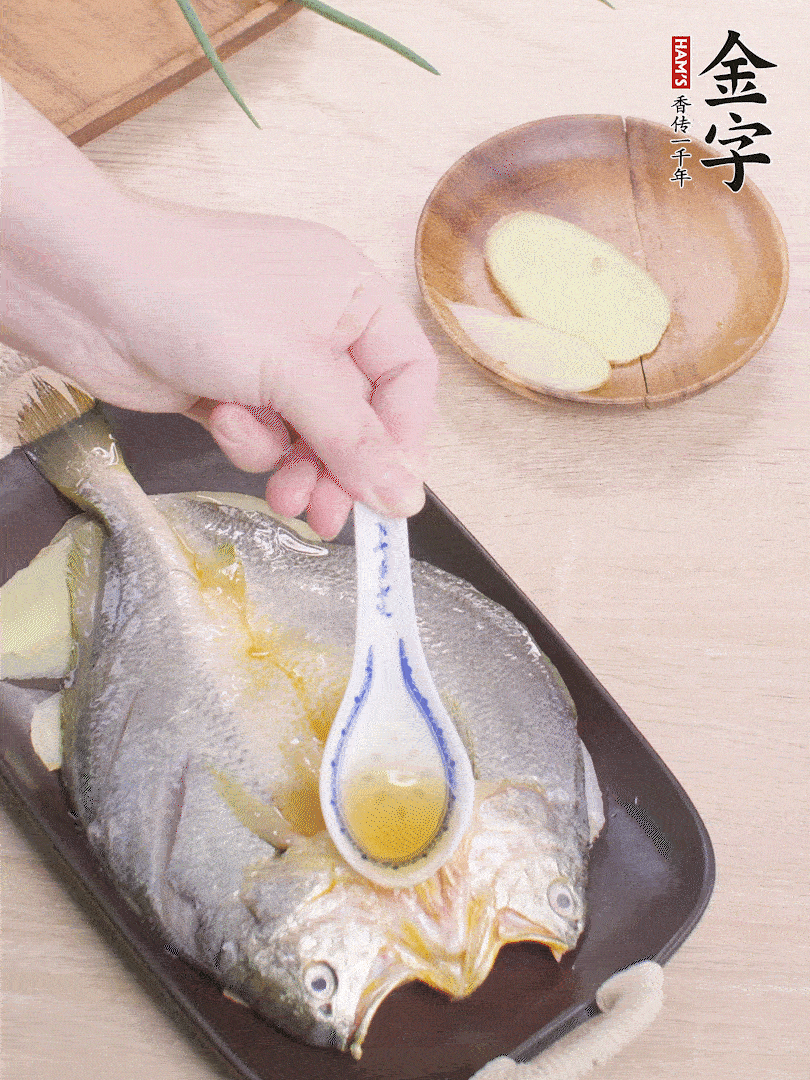 盤(pán)底鋪姜片，放黃魚(yú)，淋2勺料酒。