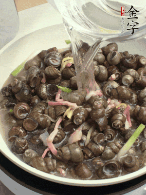倒處理干凈的螺螄翻炒，加3勺料酒。加清水蓋過螺螄，中火蓋蓋煮5分鐘。