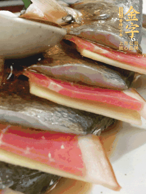魚肚中塞蔥結(jié)、火腿片，魚身上碼放姜片、火腿片，倒入混合的料汁。