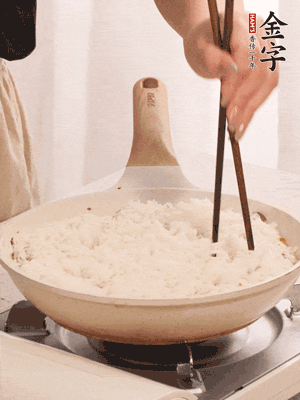 把瀝干水分的米飯均勻鋪在上面，筷子戳幾個(gè)洞，以便透氣，轉(zhuǎn)小火蓋上蓋子燜至水分收干，大概10分鐘。